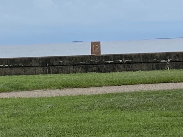Digital zoom inset of the previous photo, which is of an actual 12-inch prop to register the height of where the proposed seawall extension would lie from a sedan vehicle on the Lakeshore Drive road surface near Rip’s Restaurant. (Mandeville Daily/William Kropog)