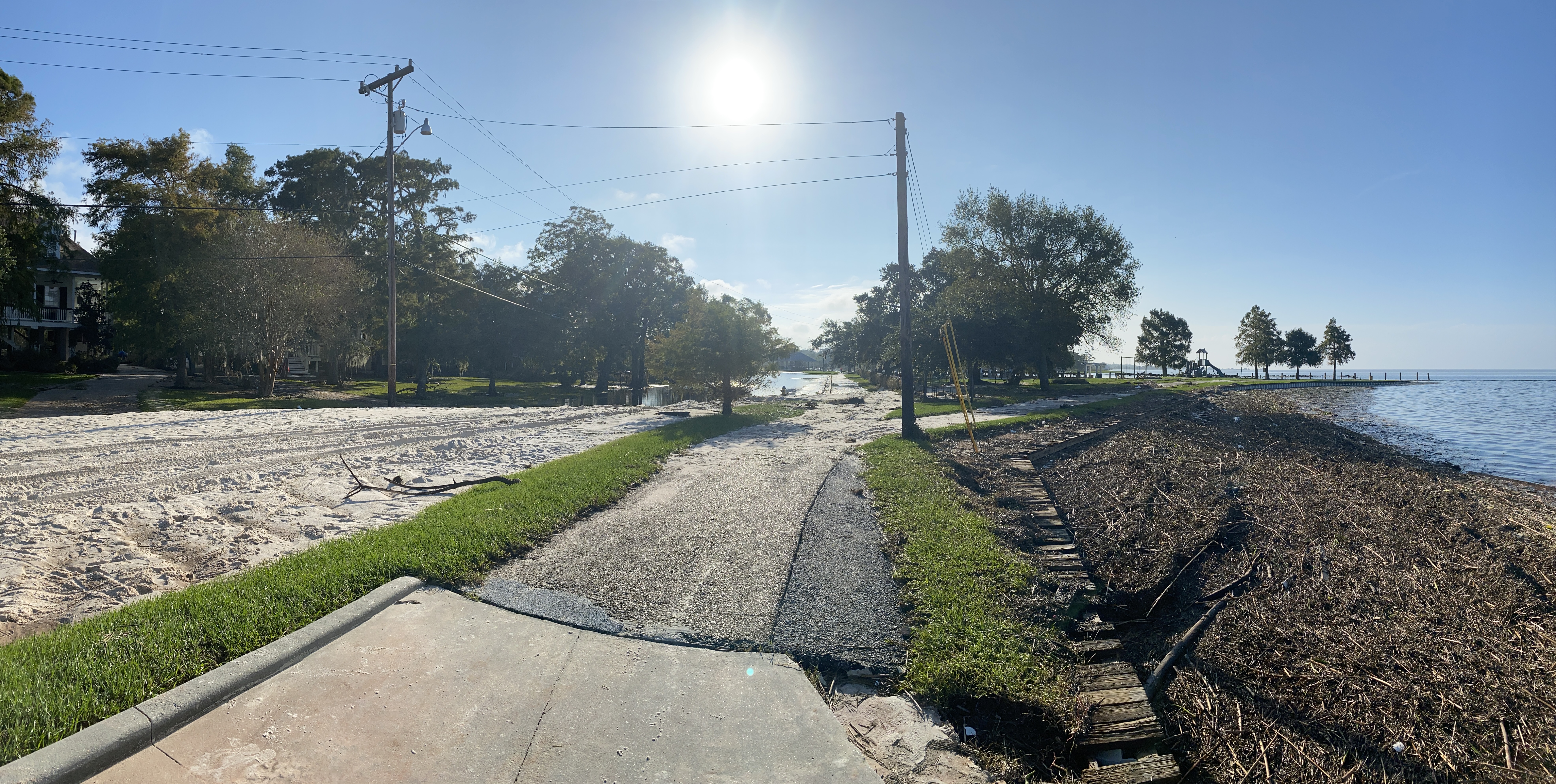 Looking east along Lakeshore Drive at what was the Mandeville Beach. The sand that was to the right has been completely moved to the roadway and north of the roadway. Part of the sidewalk at the pedestrian been was washed out too. (Mandeville Daily/William Kropog)